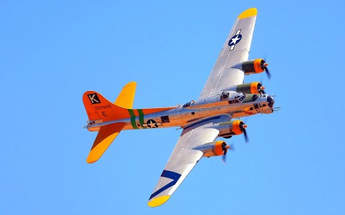 Image orange and yellow jet plane in mid air during daytime