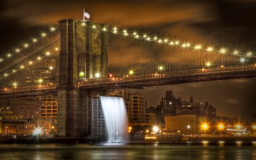 Image lighted bridge near city buildings during night time