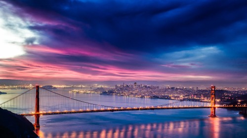 Image city skyline across bridge during night time