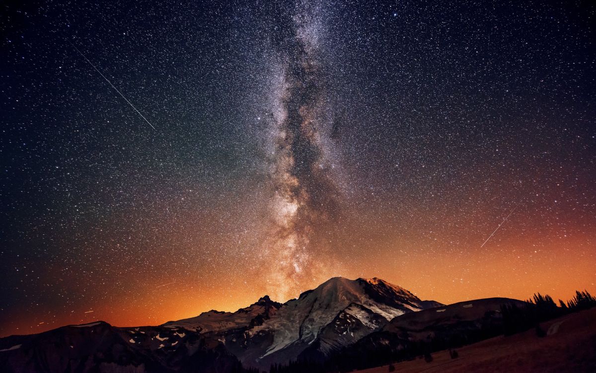 snow covered mountain under starry night