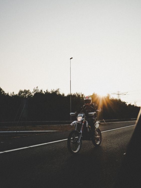 Man Riding Motorcycle Sur Route Pendant le Coucher du Soleil. Wallpaper in 2330x3107 Resolution