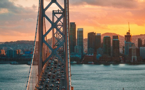 Image bridge over water near city buildings during daytime