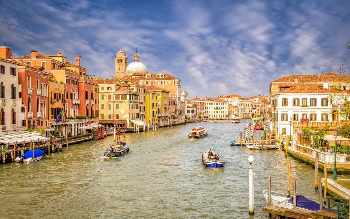 people riding on boat on river near buildings during daytime