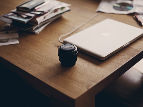 Image black camera lens on brown wooden table