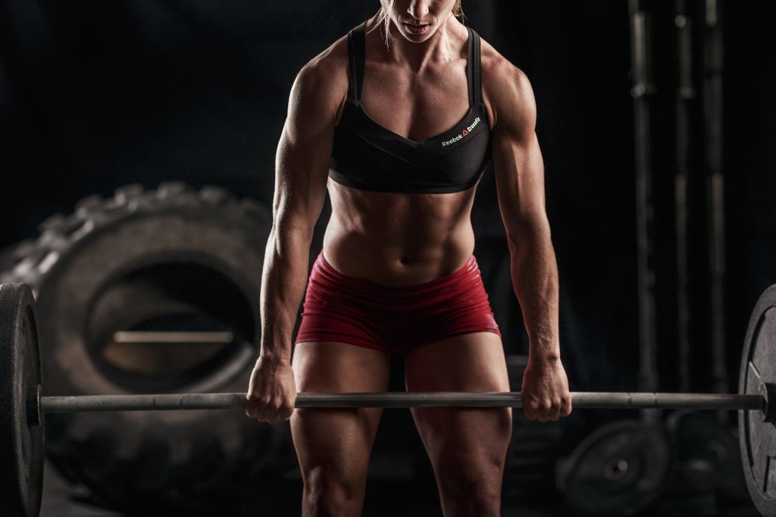 Woman in Black Sports Bra and Red Shorts Holding Black Barbell. Wallpaper in 5184x3456 Resolution