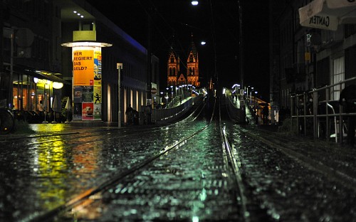 Image train rail near city buildings during night time