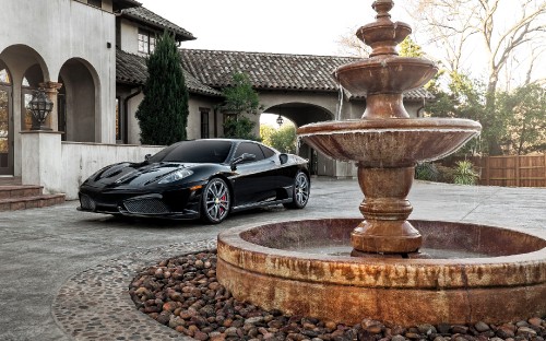 Image black coupe parked beside brown concrete fountain during daytime