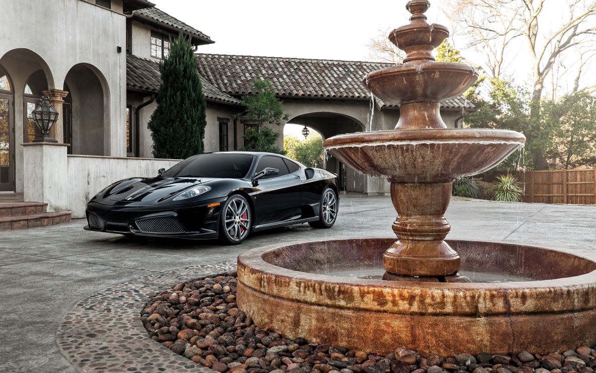 black coupe parked beside brown concrete fountain during daytime