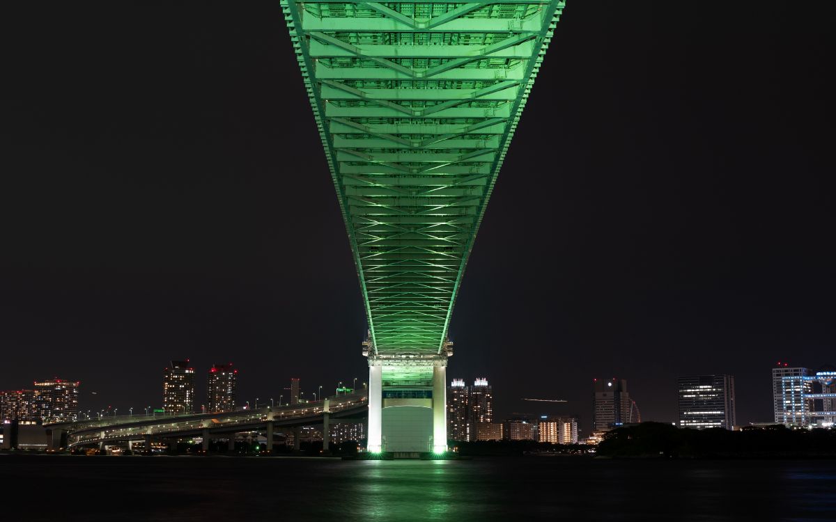 Green Bridge Over Body of Water During Night Time. Wallpaper in 3840x2400 Resolution