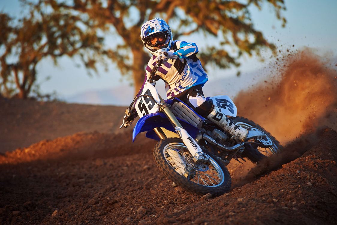 man in blue and white motorcycle suit riding motocross dirt bike