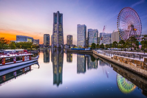 Image city skyline across body of water during night time