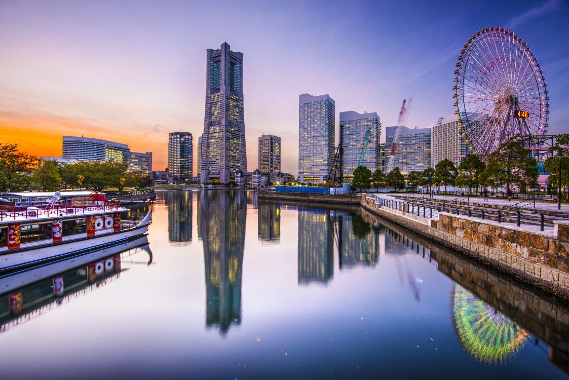 city skyline across body of water during night time