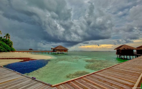 Image brown wooden dock on sea under white clouds during daytime