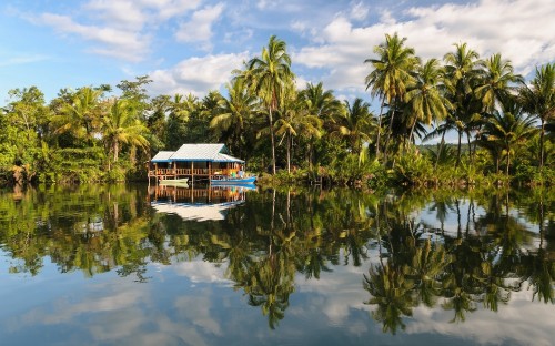 Image blue and white wooden house on lake during daytime