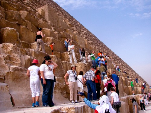 Image group of people standing on brown rock formation during daytime