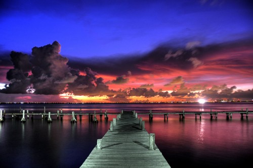 Image brown wooden dock on body of water during sunset