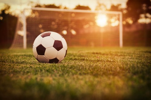 Image white and black soccer ball on green grass field during daytime