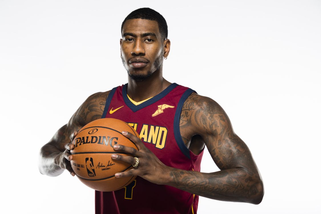 man in red and black basketball jersey holding basketball