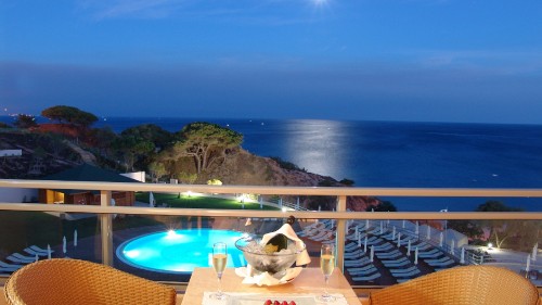 Image brown wooden table and chairs near blue body of water during daytime