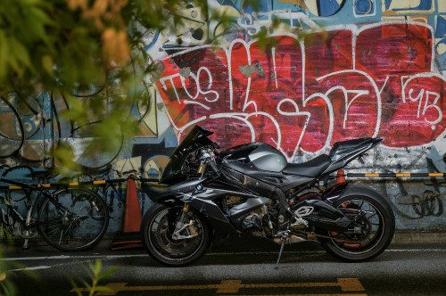 Image black motorcycle parked beside wall with graffiti