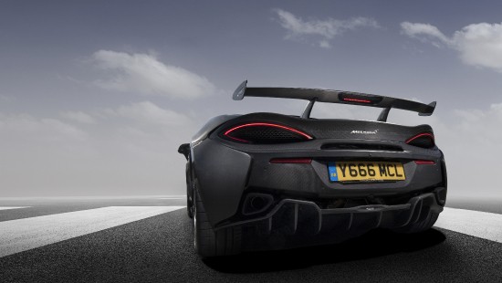 Image black porsche 911 on gray asphalt road under gray cloudy sky