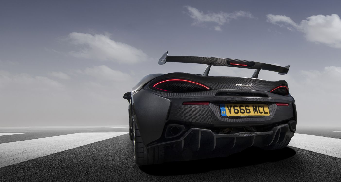 Porsche 911 Noire Sur Route Asphaltée Grise Sous Ciel Nuageux Gris. Wallpaper in 7957x4251 Resolution