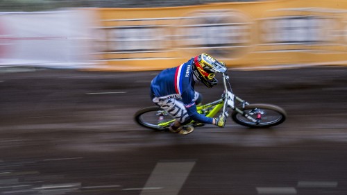 Image man in white and black racing suit riding on motocross dirt bike