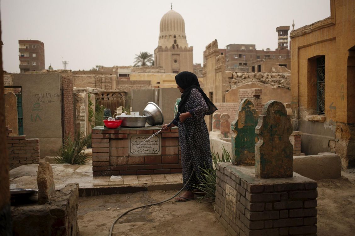 woman in black and white hijab standing on brown concrete brick during daytime