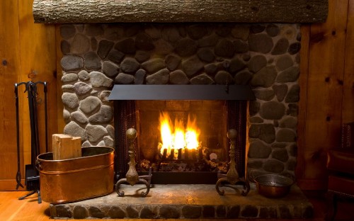 Image brown wooden armchair beside fireplace