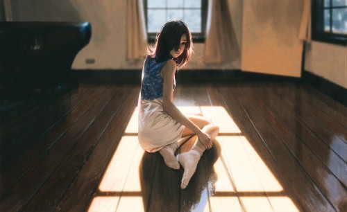 Image woman in white sleeveless dress sitting on brown wooden floor