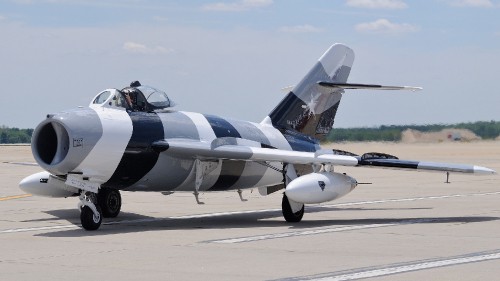 Image gray fighter plane on gray concrete ground during daytime