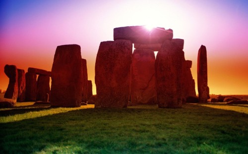 Image brown rock formation on green grass field during daytime