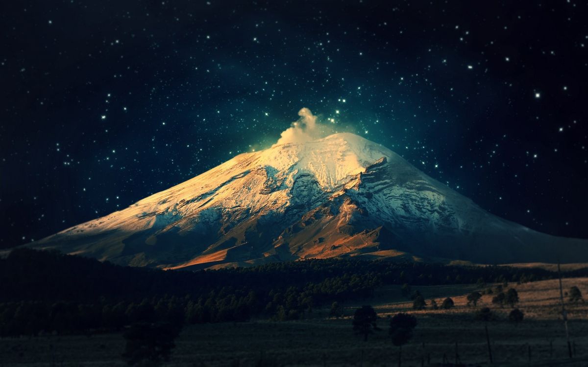 snow covered mountain under starry night