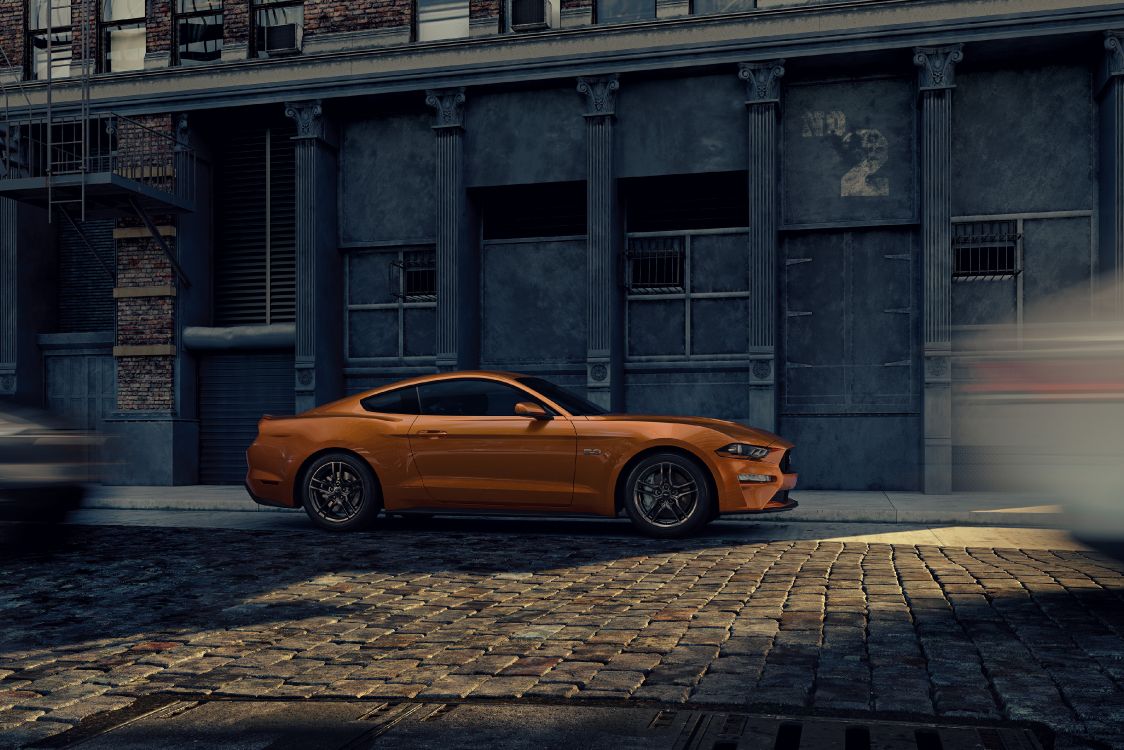 orange car parked beside building