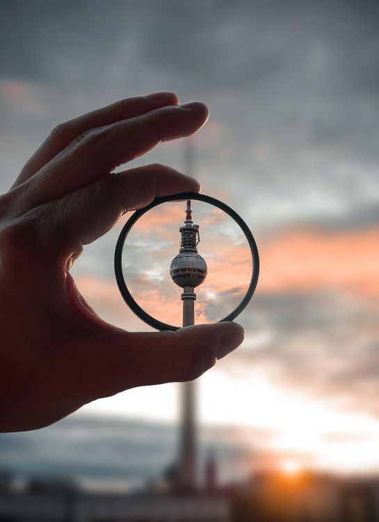 person holding magnifying glass during sunset