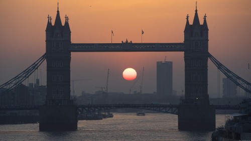 Image silhouette of people walking on bridge during sunset