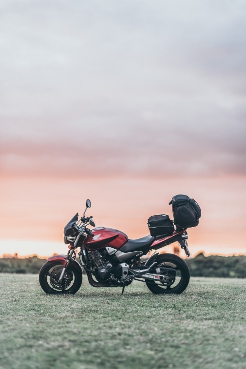 Image black and red motorcycle on green grass field during daytime