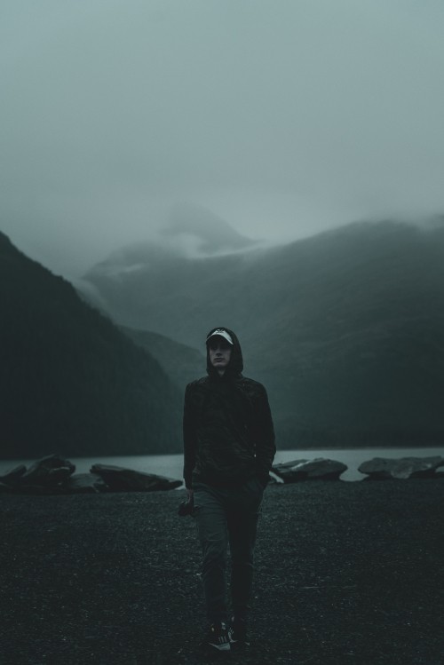 Image man in black hoodie standing on beach during daytime