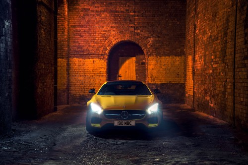 Image silver car parked beside brown brick wall