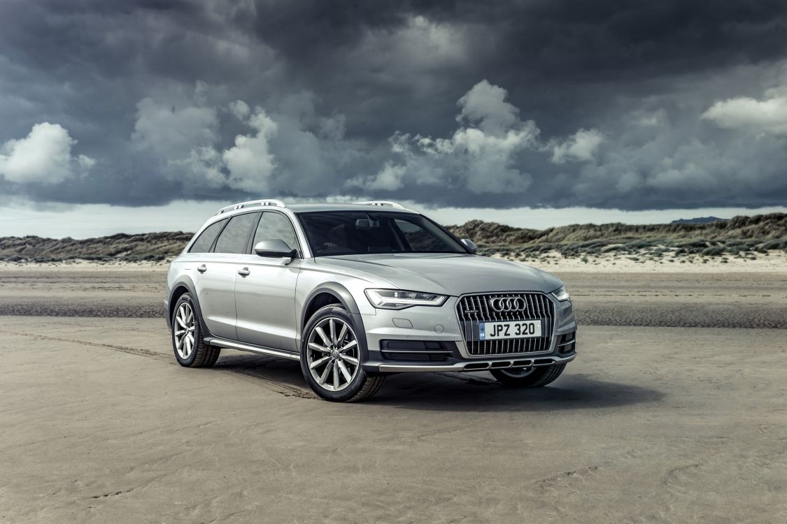 silver audi a 4 on brown field under white clouds and blue sky during daytime