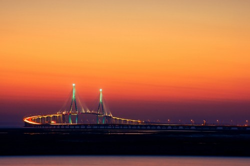 Image bridge over body of water during sunset