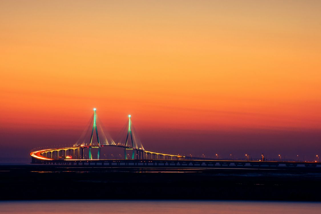 bridge over body of water during sunset