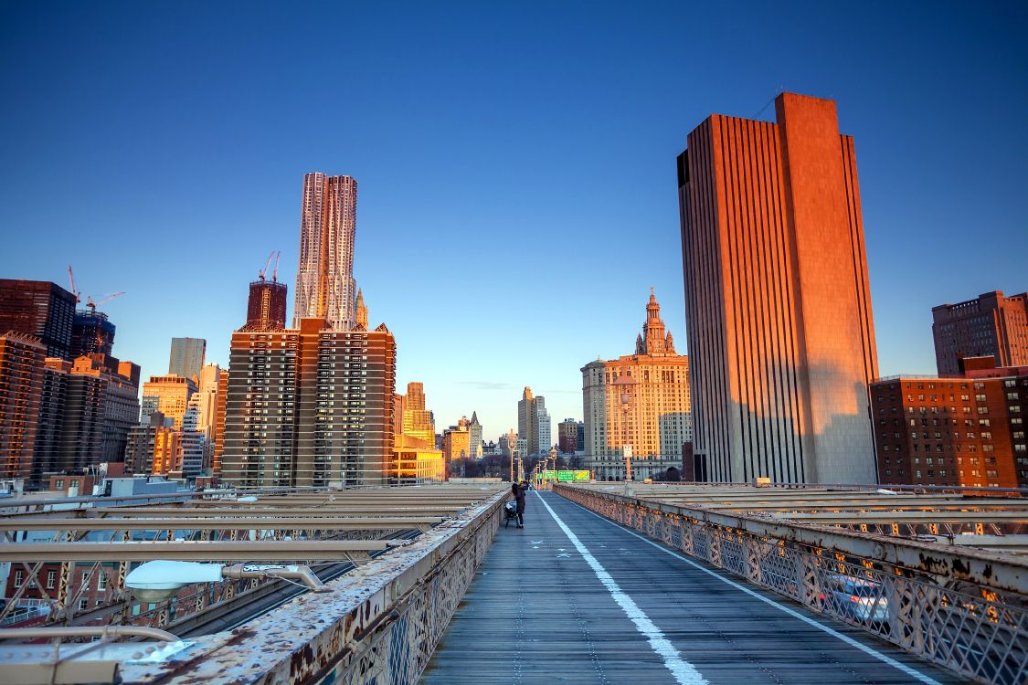 people walking on sidewalk near high rise buildings during daytime