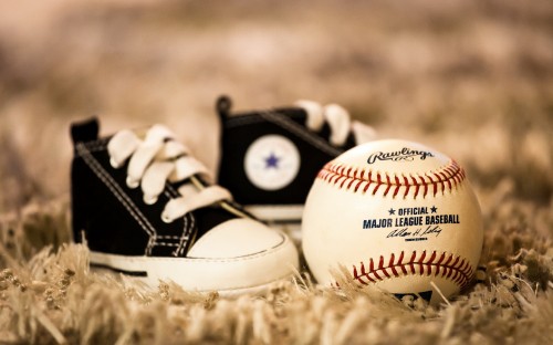 Image white and red baseball on brown grass