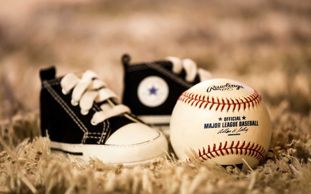 white and red baseball on brown grass