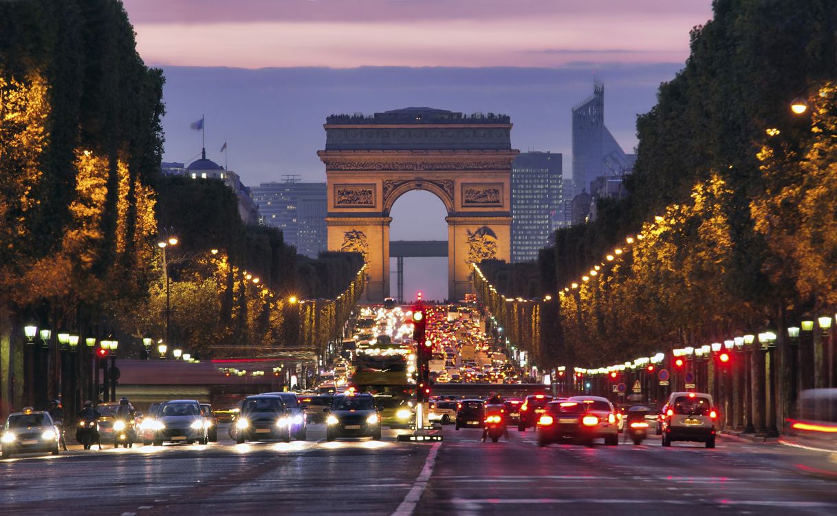 cars on road near arch gate during night time