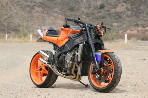 Image orange and black motorcycle on dirt road during daytime