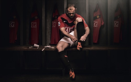 Image man in black and red nike jersey shirt and black shorts sitting on brown wooden bench