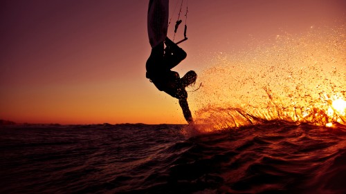 Image man in black wet suit holding white surfboard on body of water during daytime