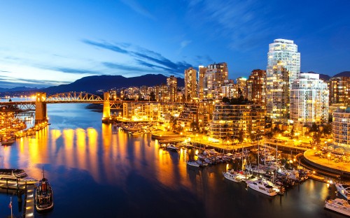 Image city skyline across body of water during night time